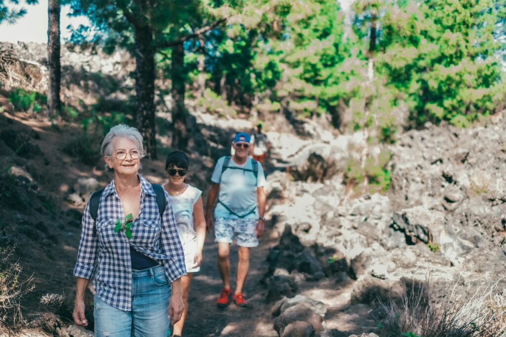 Carefree group of senior people walking in mountain footpath enjoying healthy lifestyle