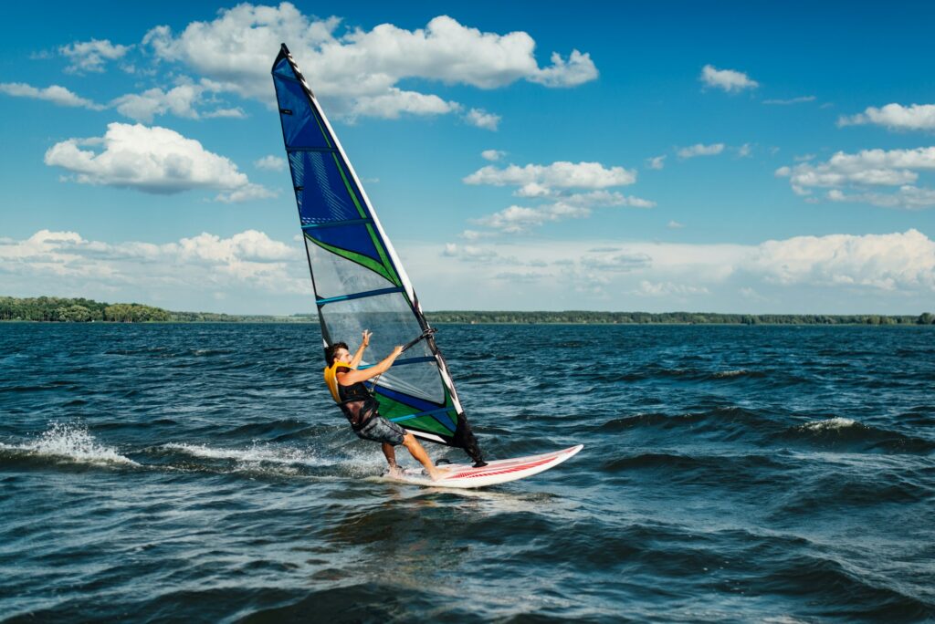 the athlete rides the windsurf over the waves on the lake